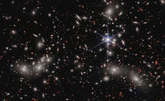 Hubble Views Massive Galaxy Cluster Warped by Gargantuan Magnifying Glass